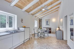 a kitchen and dining room with a table and chairs at Eco House Casa Grigia - Happy Rentals in Čunski