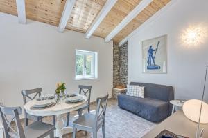 a dining room with a table and a couch at Eco House Casa Grigia - Happy Rentals in Čunski