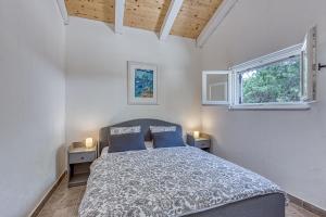 een slaapkamer met een bed en 2 ramen bij Eco House Casa Grigia - Happy Rentals in Čunski