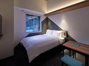a hotel room with a bed and a window at Prince Smart Inn Atami in Atami
