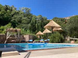 a swimming pool with chairs and umbrellas at Apartments Nora & Lucija in Baška