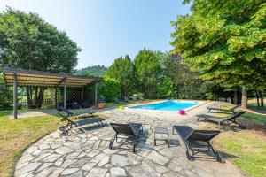 a patio with chairs and a swimming pool at Villa Cornelia , entire Villa with private pool in Corneliano d'Alba