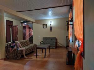 a woman sitting on a couch in a living room at Hostel Ureki Kidobani in Ureki