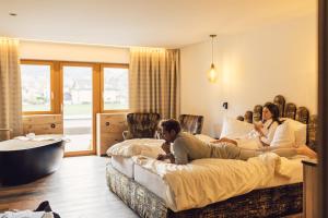 Ein Mann und eine Frau, die in einem Hotelzimmer auf Betten sitzen in der Unterkunft Hotel Jägerhof in Zams