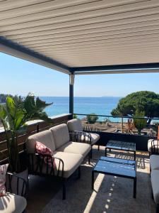 a patio with couches and a view of the ocean at Les Alcyons in Le Lavandou