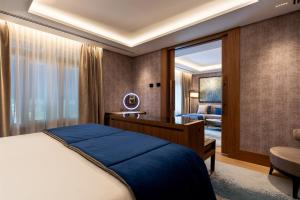 Wellington Hotel & Spa Madrid في مدريد: غرفة نوم بسرير ومكتب وكرسي