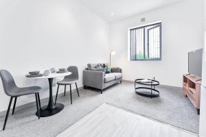 uma sala de estar com uma mesa e um sofá em Modern and Bright 1 Bed Apartment Dudley em Brierley Hill