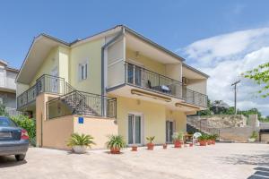 Casa amarilla con balcón y macetas en Sans Souci Split en Split