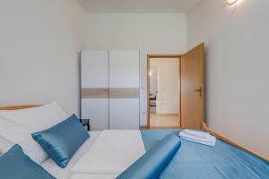 een slaapkamer met een groot bed met blauwe kussens bij Sans Souci Split in Split