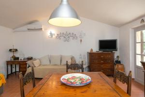 een woonkamer met een tafel en een bank bij La Poggiolina in Toscana in Guardistallo