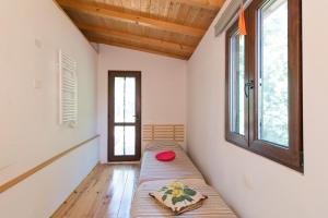 een slaapkamer met een bed in een kamer met ramen bij La Poggiolina in Toscana in Guardistallo