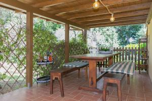 een patio met een houten tafel en stoelen bij La Poggiolina in Toscana in Guardistallo