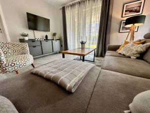 - un salon avec un canapé et une table dans l'établissement Apartament Pogorzelica - Baltic Park, à Pogorzelica