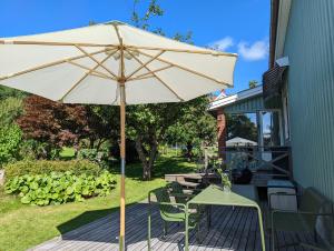 an umbrella on a deck with a table and chairs at 30-tals villa med närhet till centrala GBG in Gothenburg