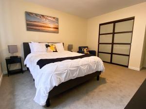 - une chambre avec un grand lit et des draps blancs dans l'établissement 2 BR Family Friendly Nature Getaway near Golf Course, à Kalamazoo