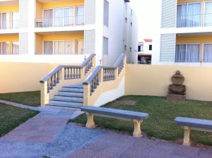 a building with stairs and a bench in the grass at Paraiso Dourado in Porto Santo