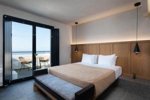 a bedroom with a bed and a view of the ocean at La Torretta in Pirgos