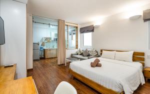 ein Schlafzimmer mit einem großen Bett und ein Wohnzimmer in der Unterkunft SaigonOne Serviced Apartment in Ho-Chi-Minh-Stadt