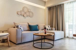 uma sala de estar com um sofá e uma mesa em Tylissos Beach Hotel - Adults Only em Lerápetra