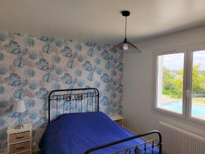 a bedroom with a blue bed with a blue and white wallpaper at Villa 7 chambres avec grande piscine à 600 m de la plage in Royan +15 photos