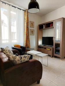 sala de estar con sofá y TV en Gite VIANY 1, en La Tour-dʼAigues