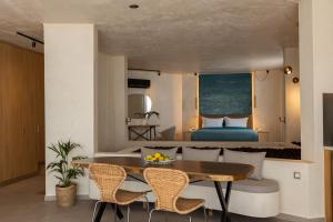 a room with a dining table and a bedroom at Anassa Ammoudi Suites in Agios Nikolaos