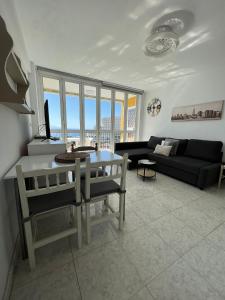 a living room with a table and a couch at Rainbow Copacabana in Playa Fañabe