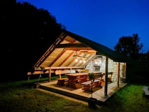 a small house with a picnic table and a tent at Leśne zacisze-pole namiotowe in Pisklaki