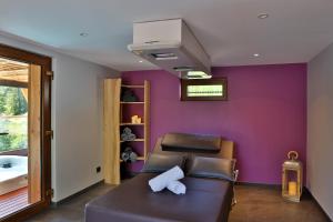 a living room with a couch and a purple wall at Eden du Boenlesgrab in Lautenbach
