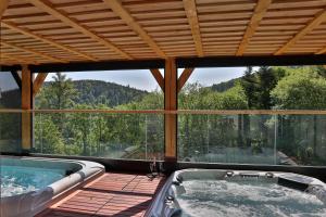 a hot tub in a house with a mountain view at Eden du Boenlesgrab in Lautenbach