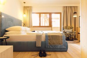 Schlafzimmer mit einem großen Bett mit blauem Kopfteil in der Unterkunft Hotel Jägerhof in Zams