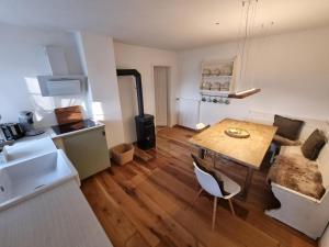 a kitchen and living room with a table and a couch at Charmantes Eifel Ferienhaus an der Schavener Heide in Mechernich