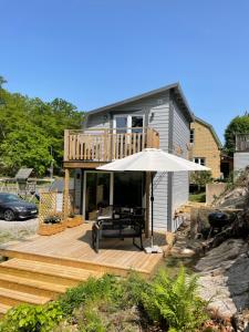 a house with an umbrella and a bench on a deck at TinyHouze in Karlskrona