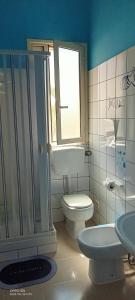 a bathroom with a toilet and a shower and a sink at Villa Scavuzzo in Realmonte