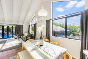 un soggiorno con tavolo e una grande finestra di Oasis Ode Retreat with pool and spa ad Auckland