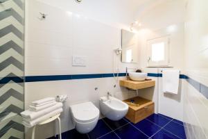 a bathroom with a white toilet and a sink at Sharon House in Amalfi