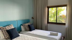 a hotel room with two beds and a window at Blue Ocean Suites & Apartments in Trou dʼ Eau Douce