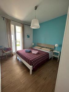 ポッツァッロにあるVilla Chiaraの青い壁のベッドルーム1室(ベッド1台付)