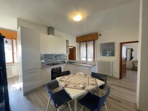 a kitchen with a table and a table and chairs at Oasi di Relax in Santa Maria di Scacciano