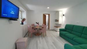 - un salon avec une table et un canapé vert dans l'établissement Apartment Irene, à Sečovlje