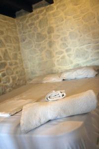 a bed in a room with a towel on it at Volcano View Nisyros in Mandrakion