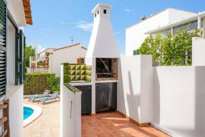 a white house with a backyard with a white fence at S Olivera in Port d'Addaia