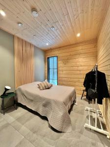 um quarto com uma cama e uma parede de madeira em Black Work Levi Aarni em Kittilä