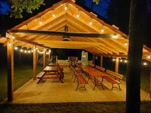 a wooden pavilion with wooden tables and benches at Leśne zacisze-pole namiotowe in Pisklaki +12 photos