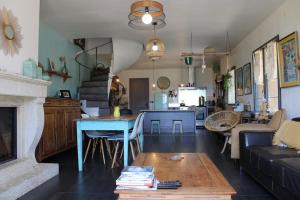 een woonkamer met een blauwe tafel en een keuken bij Mas dans vignoble classé, plages, randos, village. in Le Pradet
