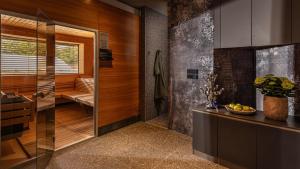 a bathroom with a walk in shower next to a kitchen at Hotel Terme Jezercica in Donja Stubica +26 photos