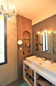 een badkamer met een wastafel en een spiegel bij Mas dans vignoble classé, plages, randos, village. in Le Pradet