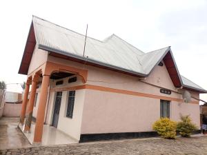 a building with a metal roof on top of it at Randa's House I Homestay in Ruhengeri