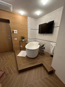La salle de bains est pourvue d'une baignoire et d'une télévision murale. dans l'établissement View Room, à Bacoli