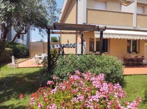 a house with a garden with flowers in the yard at Sette cuscini affittacamere in Porto Recanati